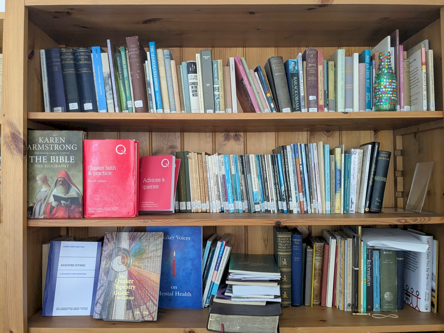 Quaker library - photos of three bookshelves. Visible copies of Quaker Faith and Practice, The King James Bible and others.